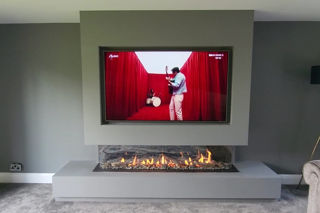 Grey media wall with recessed television and wide fireplace